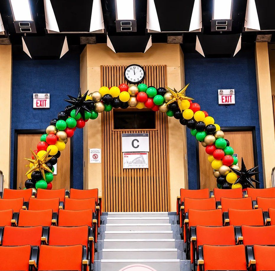 Red, yellow, green and black arch over a stage entrance