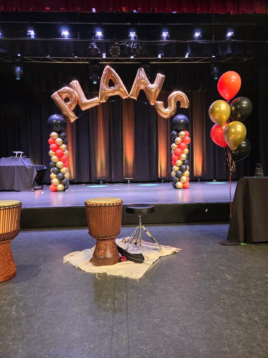 Foil letters on a stage with balloon bunches