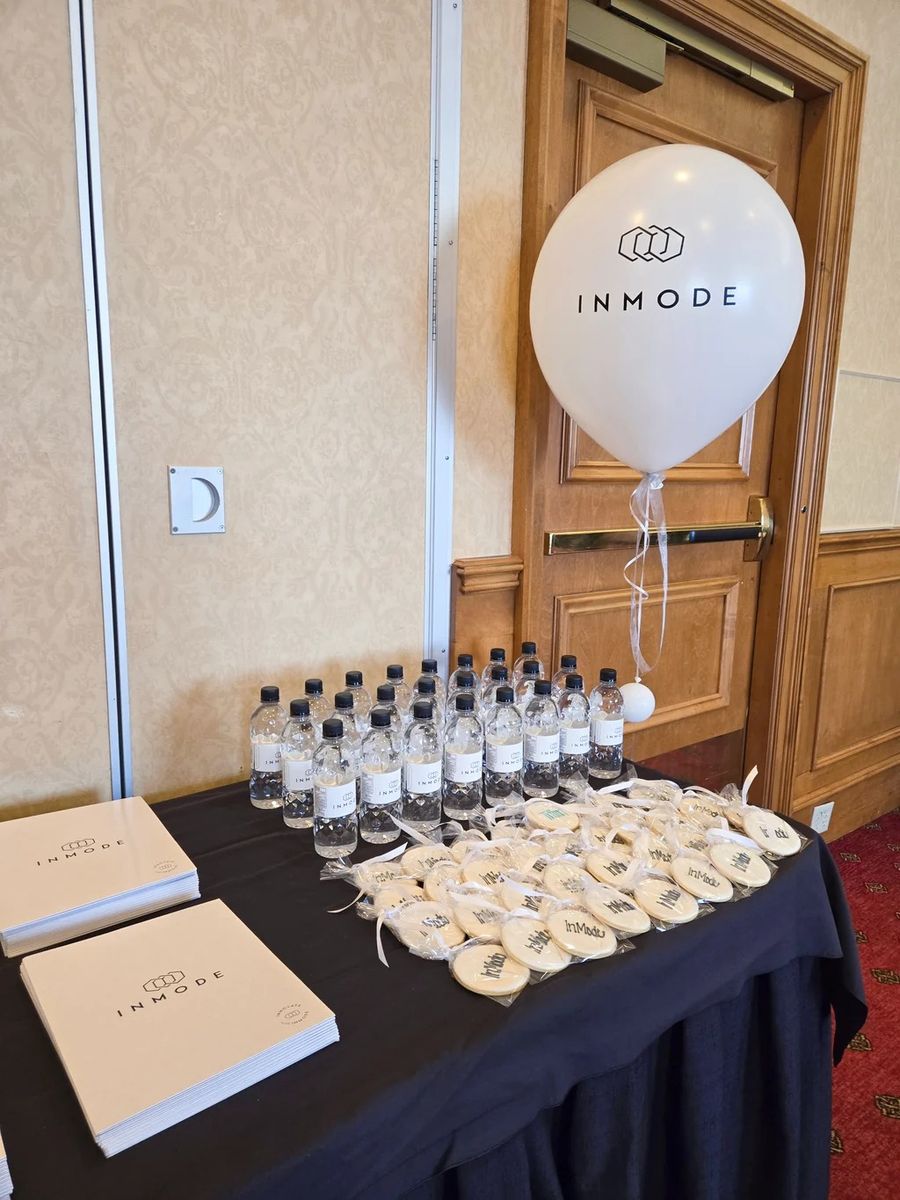 White InMode logo balloon over a welcome table