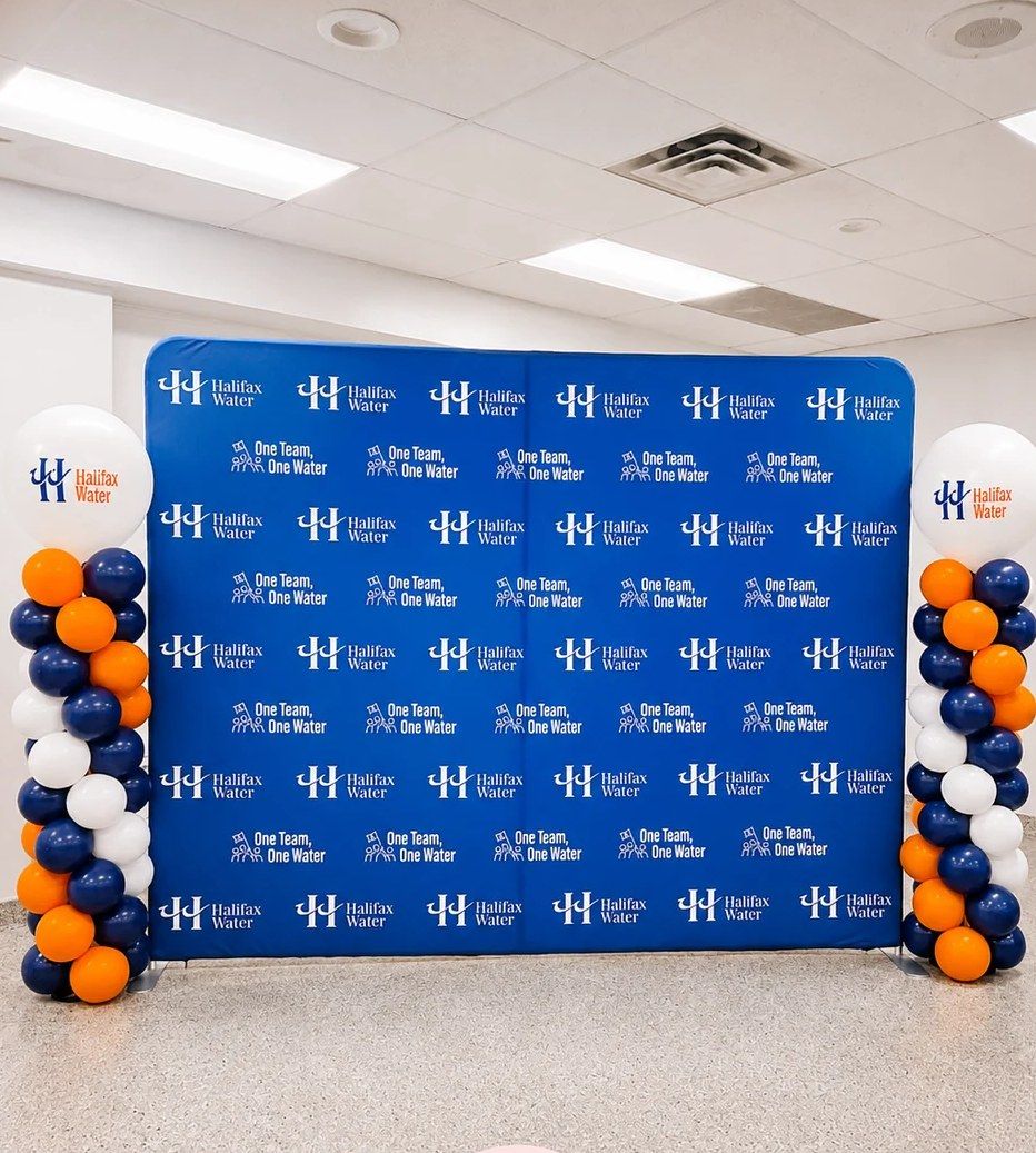 Halifax Water step-and-repeat backdrop between navy, orange and white columns