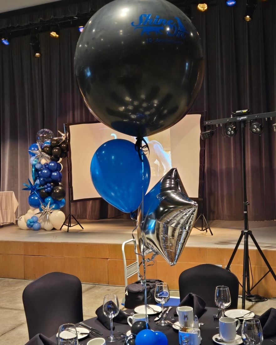 Black jumbo balloon printed with a 10th anniversary logo over a gala table