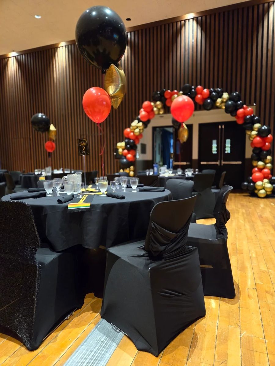 Black, gold and red organic arch over gala tables