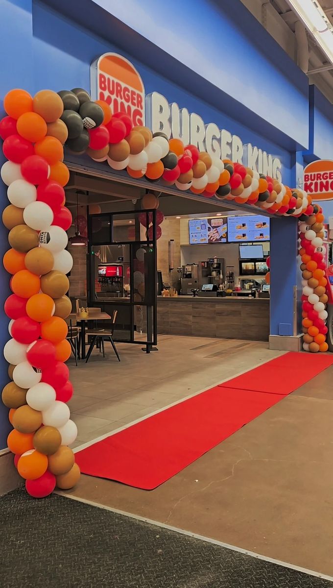 Burger King entrance framed by an orange, red and white organic garland