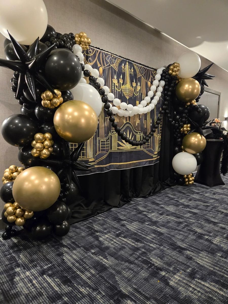 Black, gold and white organic garland around a printed backdrop