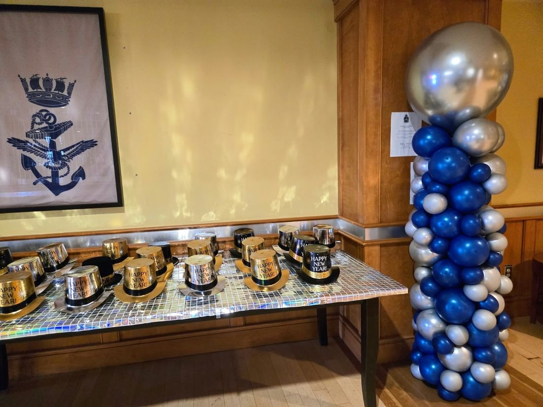 Navy and silver column with a chrome topper beside a table of New Year's hats